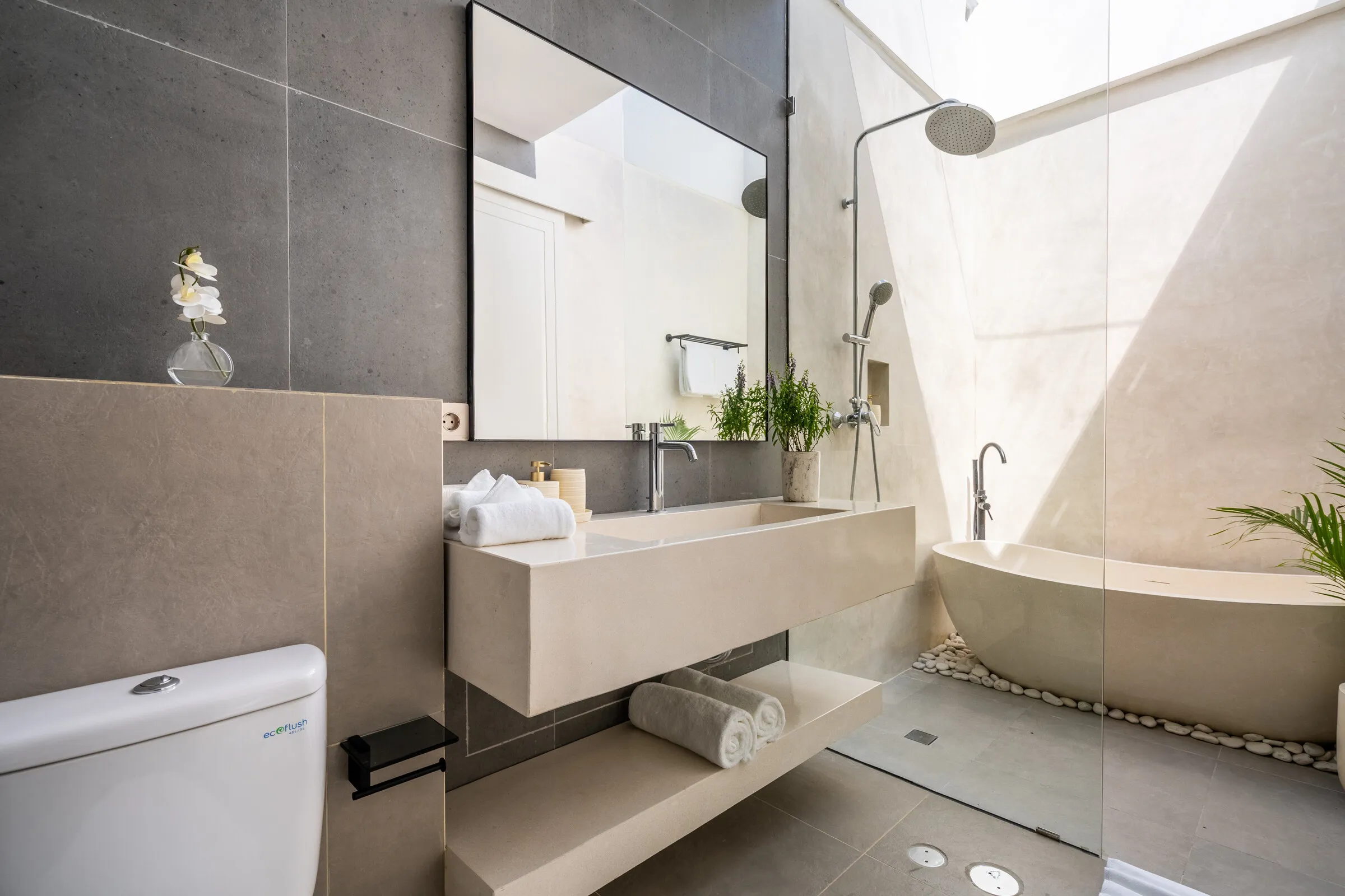 Bathroom with freestanding bathtub, stone basin and rain shower