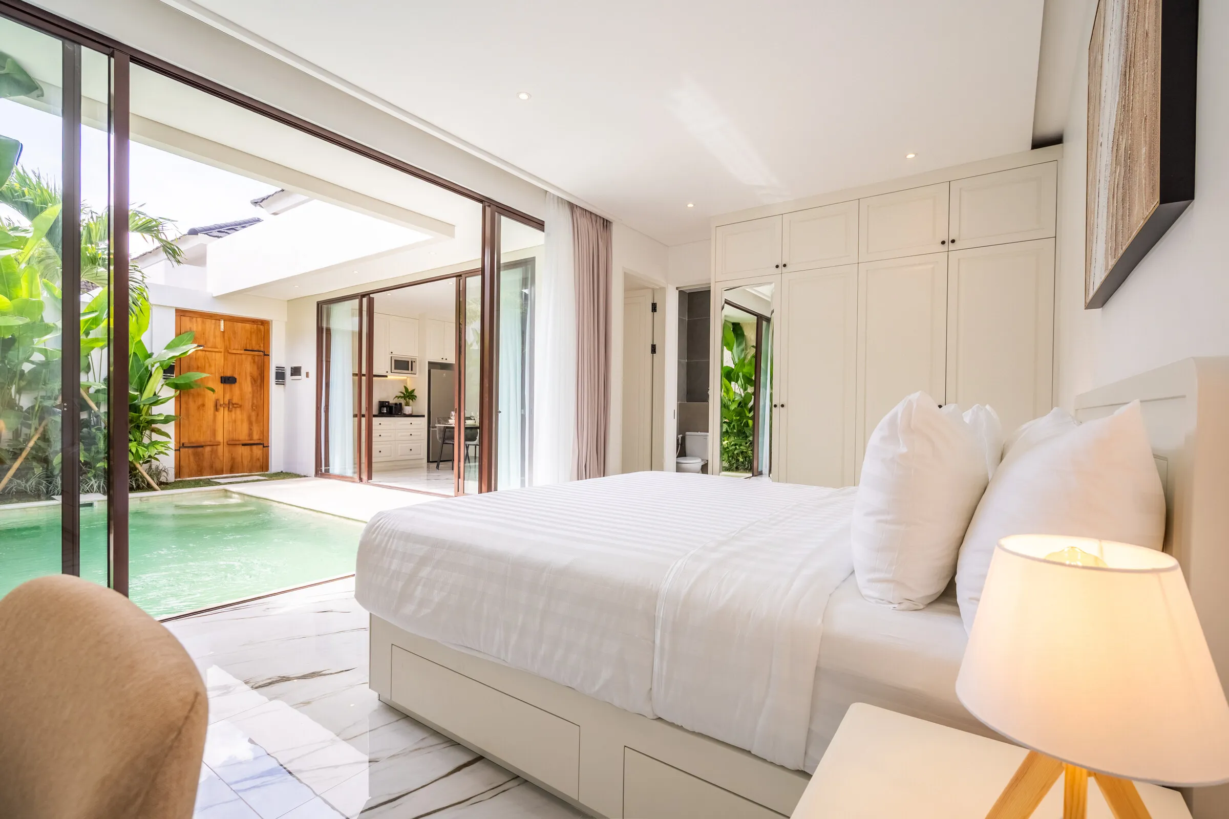 King bed looking out through glass doors to the private pool