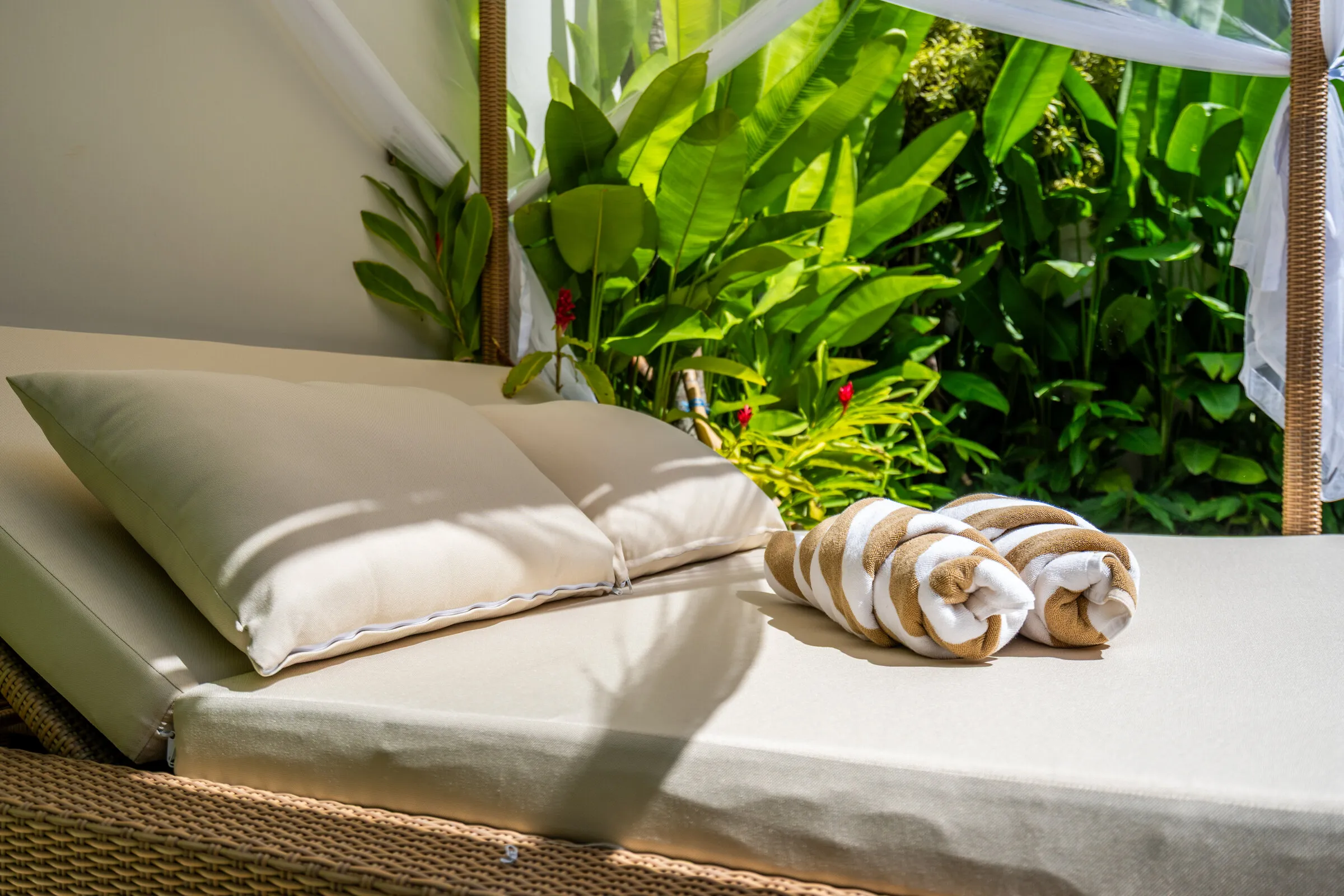 Daybed cushions and rolled towels beside the garden