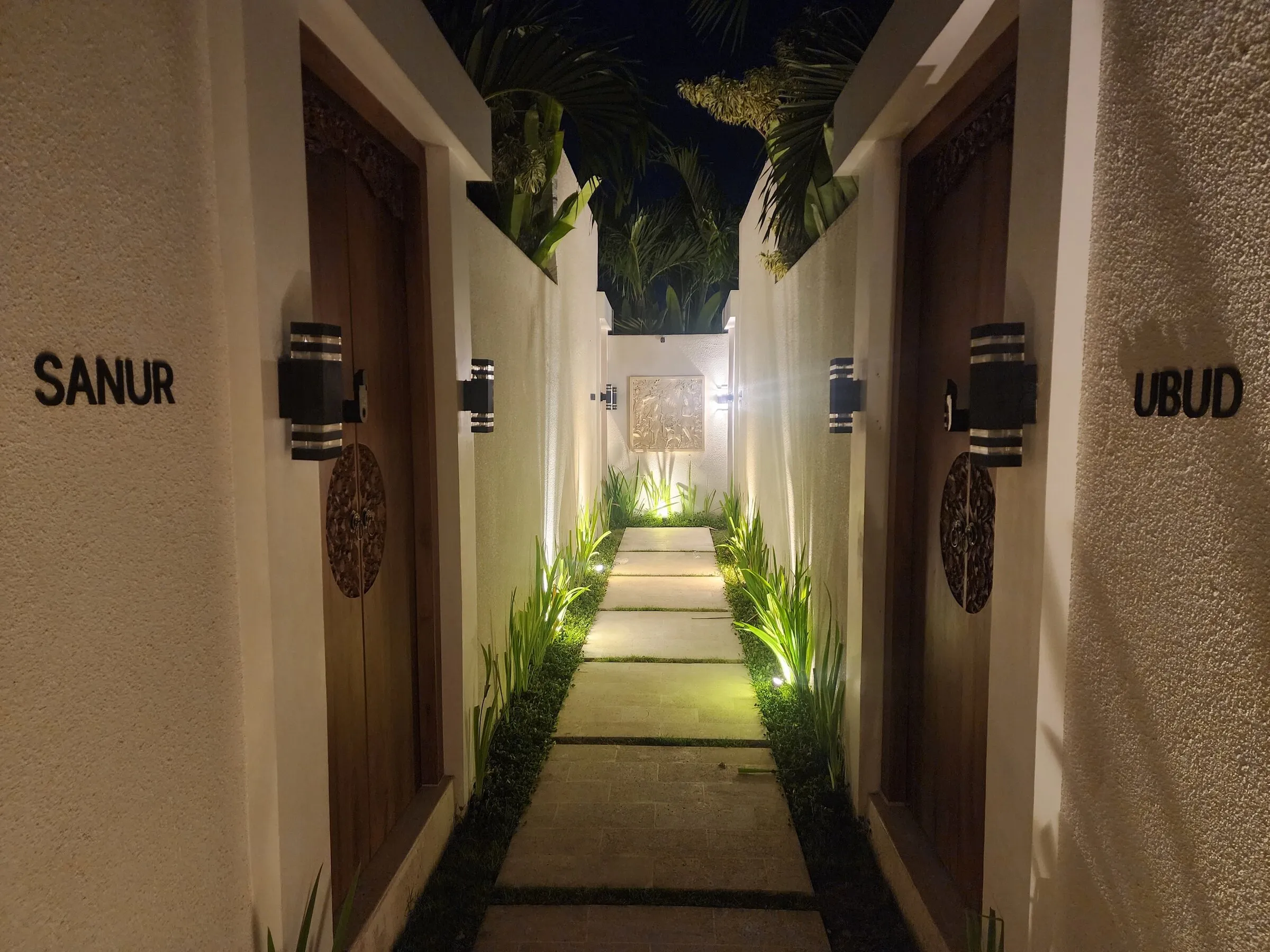 Lit garden path to the villa entrances at night